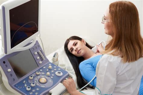 Doctor Using Ultrasound Scanning Machine Examining Female Neck Stock