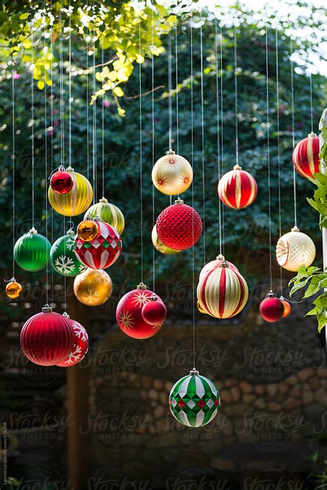 Many Colorful Christmas Balls Hanging In The Garden With Sunlight By