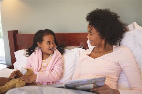 Happy African American Mother And Her Daughter Reading A Book Stock Image Image Of Adult Care