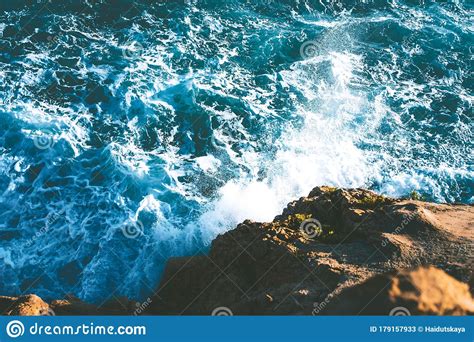 Top View Of Sea Waves Hitting Rocks On The Beach With Turquoise Blue