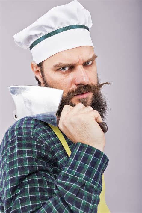 Studio Shot Of An Angry Bearded Man Holding A Butcher Knife Stock Image