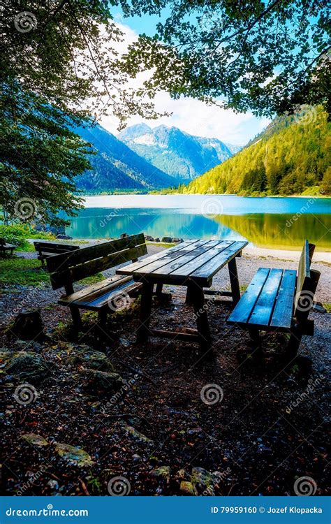 Beautiful Landscape Wooden Bench Overlooking The Lake And Mountains