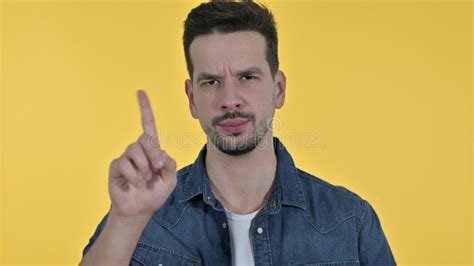 Attractive Young Man Saying No By Finger Yellow Background Stock Image