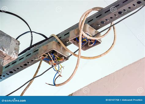 Electrical Exposed Connected Wires Protruding From Socket On White Wall