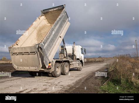 Dump Truck With A Raised Body On A Dirt Road The Process Of