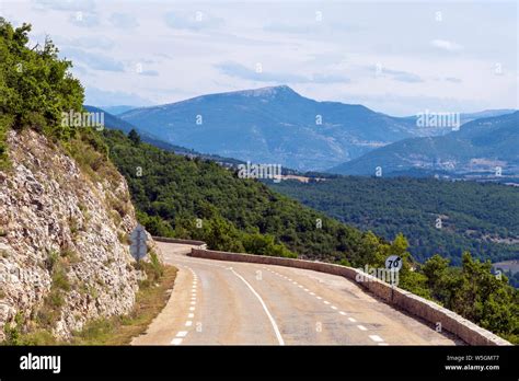 Asphalt Road Curve In The French Mountains With Mountain Peak And Green