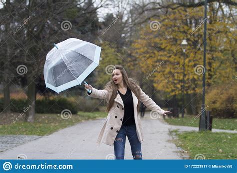 The Umbrella Flew To The Side Due To High Windsa Young Girl With Long