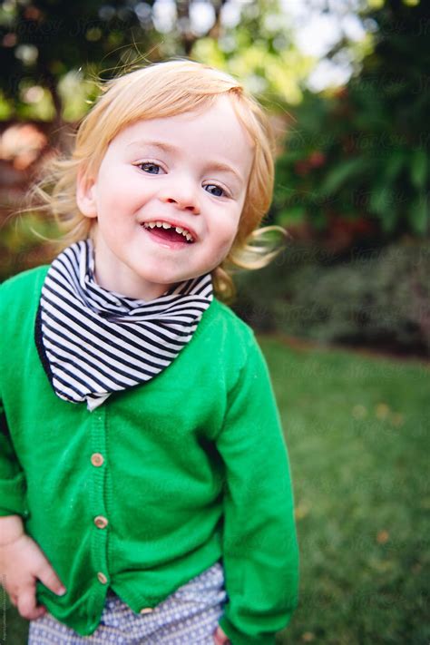 «Smiling Happy Toddler Playing In A Yard» del colaborador de Stocksy