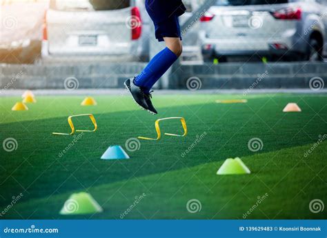 Young Boy Soccer Player Jogging And Jump Between Marker And Yellow
