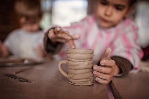 Crianças lindas brincando com argila de modelagem na oficina de cerâmica artesanato e arte em