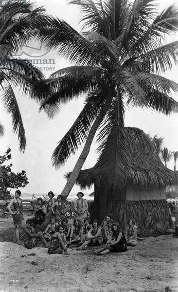 Young Women In Polynesian Flapper Costumes Lounge Under A Coconut Palm On Opening Day At Tahiti