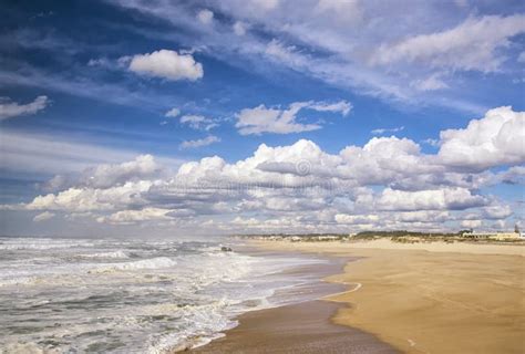 Sandy Beach And Sea Against A Blue Sky With White Clouds Stock Photo