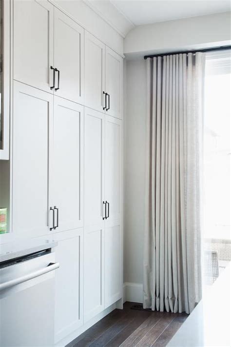 The actual cabinet is 3.25 inches the wall, countertop 2.25. Off white curtains hang from a bronze curtain rod on a ...