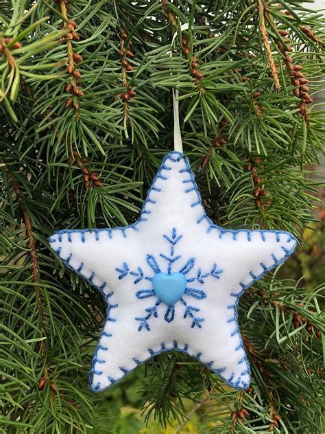 A Blue And White Star Ornament Hanging From A Tree