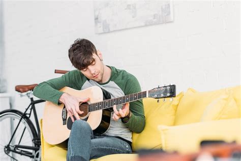 Premium Photo Handsome Young Man Playing Acoustic Guitar While
