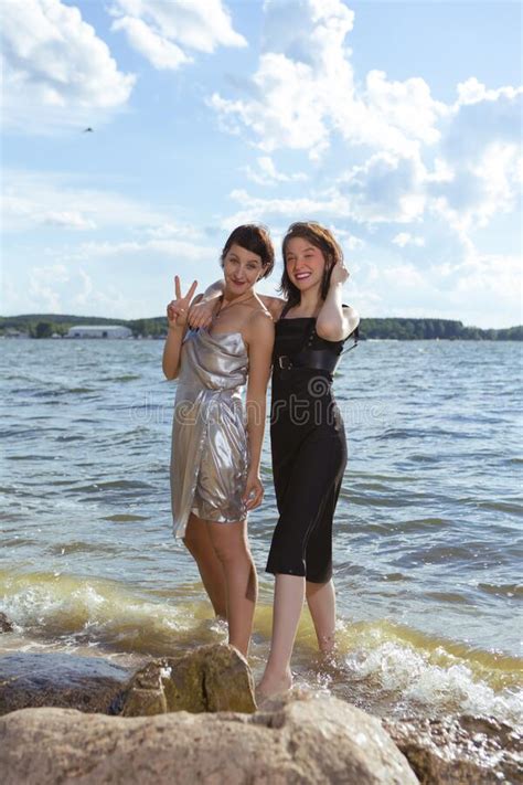 portrait of lesbian couple girls females having time resting or relaxing outdoors at seashore
