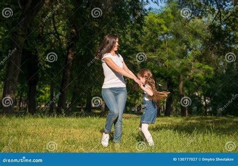Mom And Daughter Spinning On The Lawn Holding Hands Stock Image Image Of Green Hand 130777027