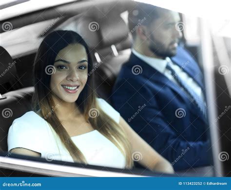 Portrait Of A Woman In A White Dress In Her Car In The Back Seat Stock