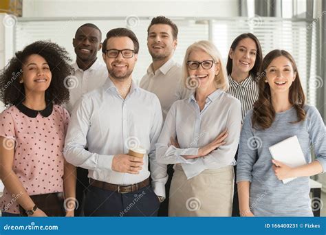 Smiling Diverse Employees Posing For Photo In Office Stock Image