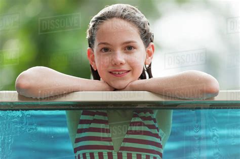 Girl In Bikini Leaning On Edge Of Swimming Pool Smiling Portrait