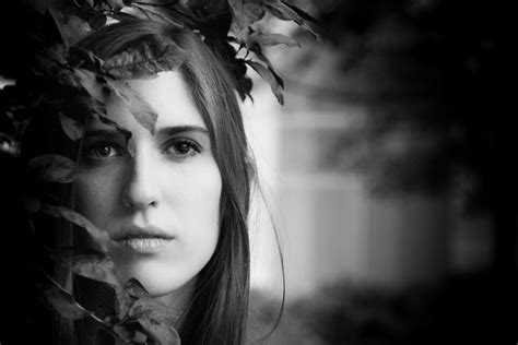 Black And White Portrait Shot Of Attractive Dark Haired Womans Head Amongst Leaves Monochrome