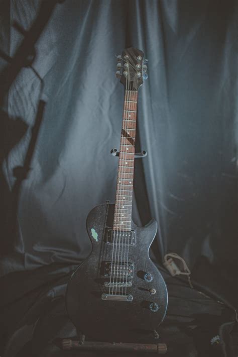 Guitarra Eléctrica Negra En Soporte De Guitarra En La Parte Delantera