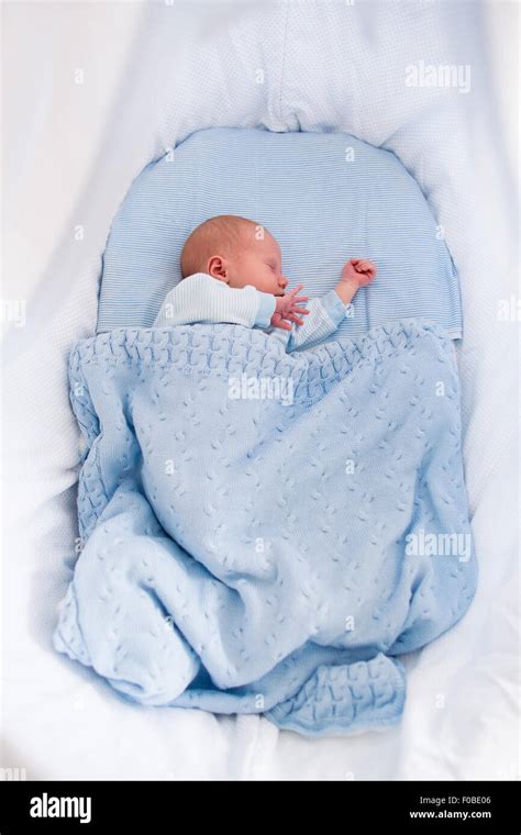 Newborn Baby Boy In Bed New Born Child Sleeping Under A Blue Knitted