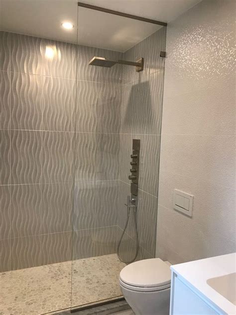 Glasscrafters' team fabricated and installed the shower enclosure for this stunning bath space. Full height stationary spray panel- a simple solution for this modern shower | Glass shower ...