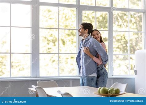 Happy Millennial European Wife Hugs Her Husband Behind In Modern