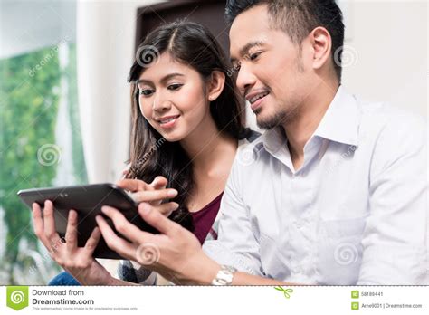 indonesian couple using tablet computer at home stock image image of asian girl 58189441