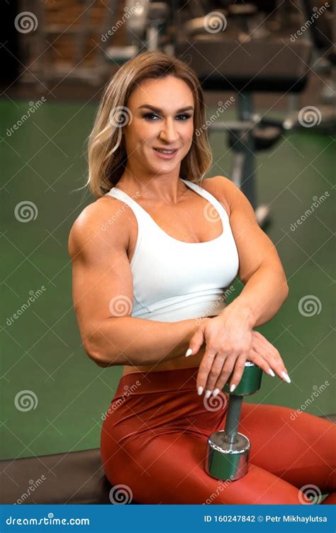 Blonde Bodybuilder Woman Is Doing Biceps Lift In Trainer Simulator Bw