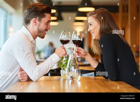 Amorous Young Couple Having A Rendezvous At The Restaurant Drinking A Glass Of Red Wine Stock