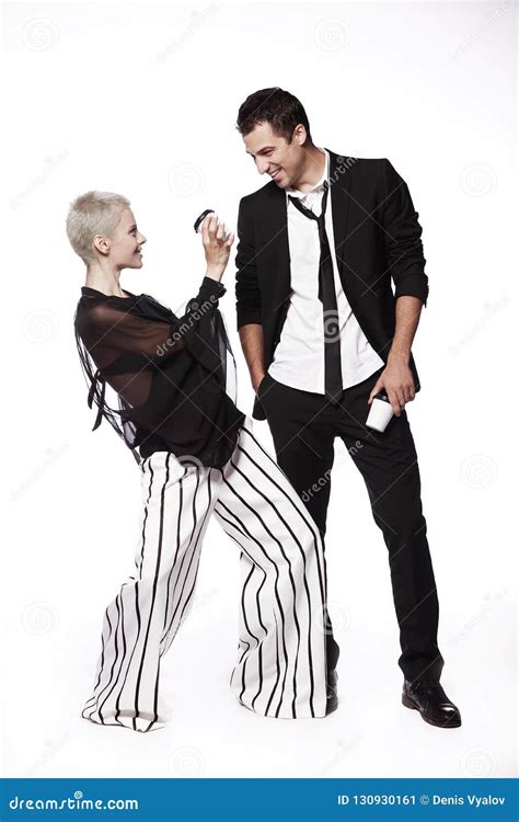 Cheerful Guy In A Black Suit And A Girl On A White Background Playful