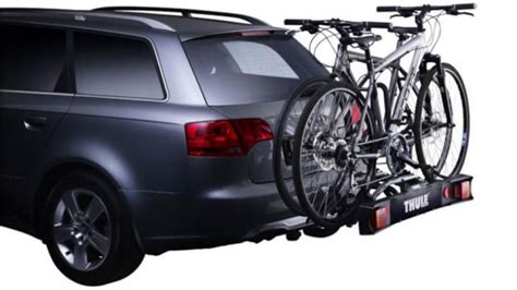 A Car With Two Bikes On The Back Rack And One Bike Attached To The Trunk