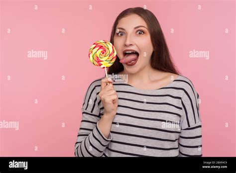 Portrait Of Funny Woman Sticking Out Tongue Licking Lollipop Tasting Sweet Round Rainbow Candy