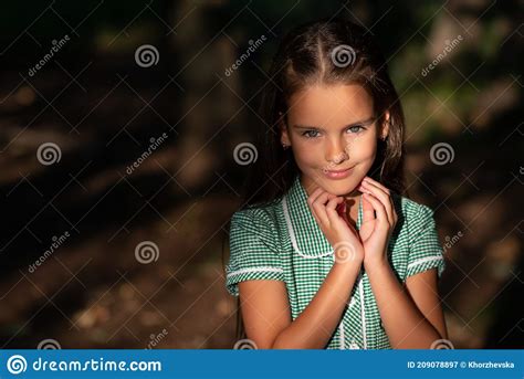 Pretty Little Brunette Girl Posing In Forest Near Tree With Sun Light At Her Beautiful Face