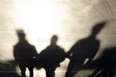 Shadows Silhouettes Of Three Men Walking On Sunset Promenade Stock