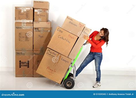 Young Woman Moving Boxes With With A Hand Truck Or Dolly Stock Image