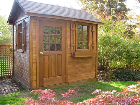 A Small Wooden Shed Sitting In The Middle Of A Yard With Trees And