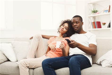 Smiling African American Young Couple Watching Tv At Home Stock Image