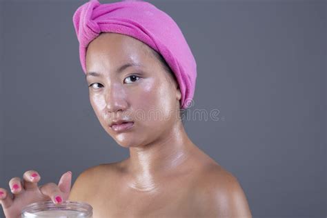 Beautiful Ethnic Chinese Woman Taking Care Of Her Face With Face Cream
