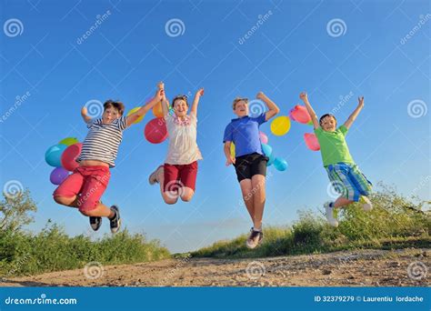 Happy Children Jumping On Field With Balloons Stock Image Image Of