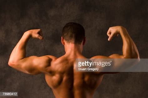 Muscular Man Flexing Back Arm And Shoulder Muscles High Res Stock Photo