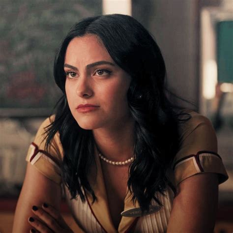 a woman sitting in front of a window with her arms crossed and looking off to the side