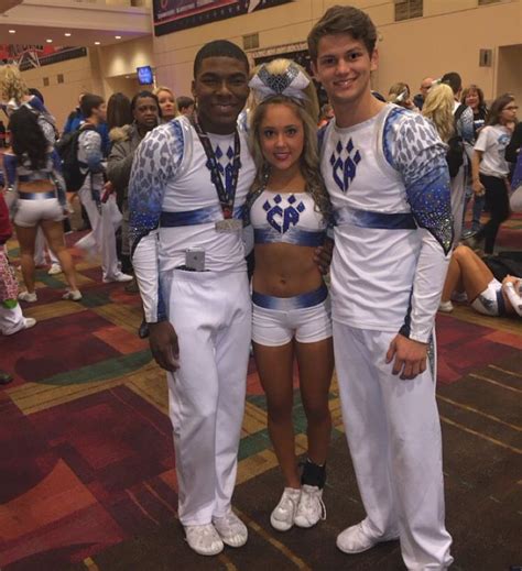 two men and a woman dressed in cheerleader outfits