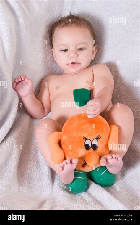 Cute 6 Month Old Baby Playing With Orange Soft Toy Stock Photo Alamy