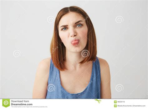 Cheerful Young Pretty Brunette Girl Showing Tongue Making Funny Face