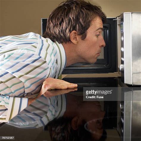 Man Looking Into Microwave Photos And Premium High Res Pictures Getty