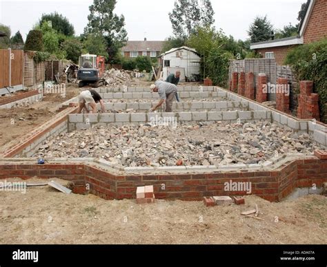 Labourers Hand Picking And Levelling Hardcore Rubble Around Foundation