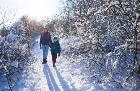Woman With A Child On A Winter Hike In The Mountains Stock Photo